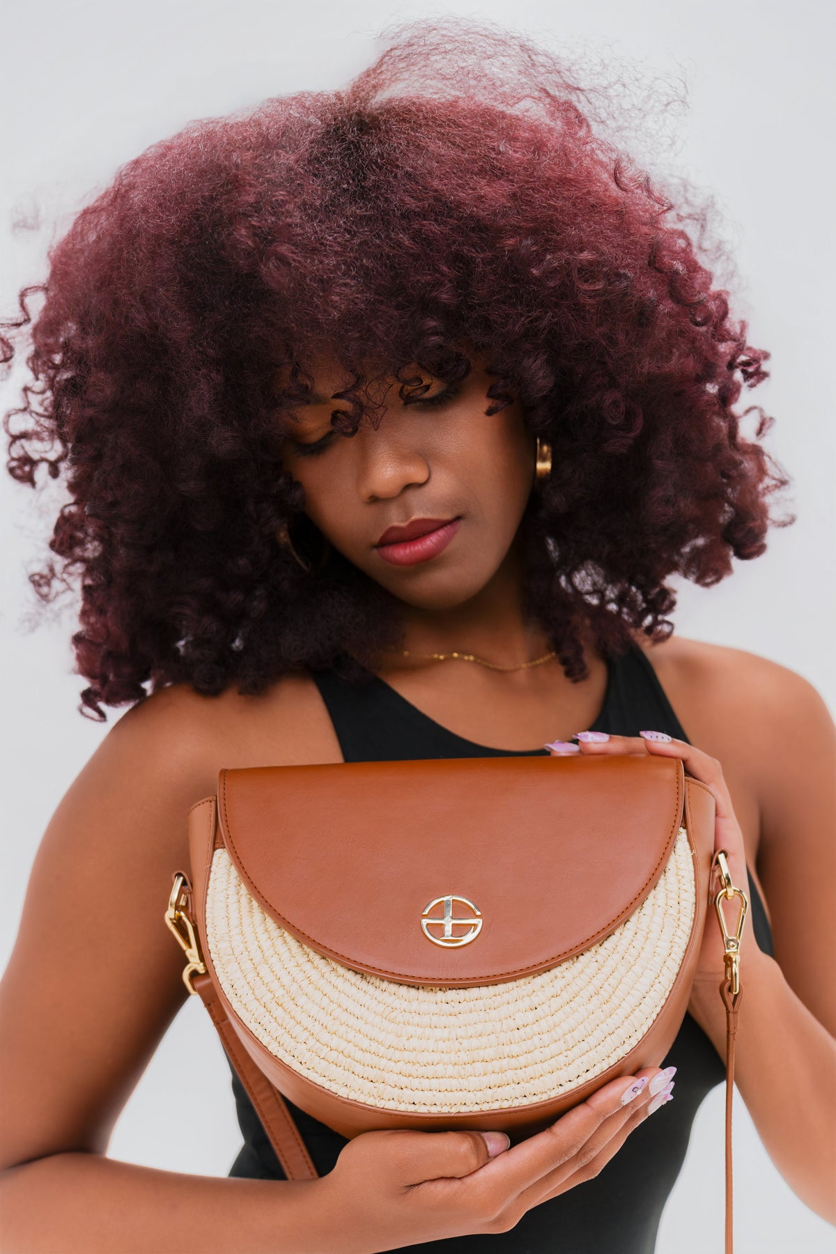 Sac demi-lune LUNA en cuir et raphia présenté à la main